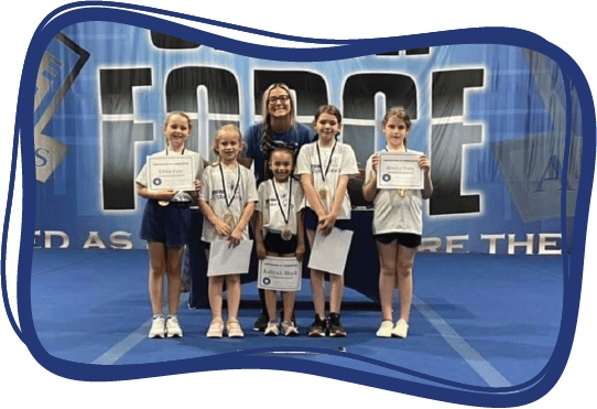 A group of Sparklers cheerleaders stands together with their coach, holding their awards and wearing their medals.